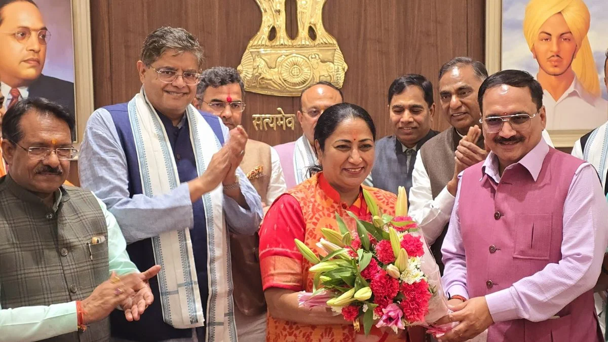 Baijayant Panda applauding at a party gathering in Delhi, beside a woman holding a bouquet of flowers