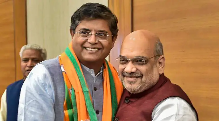 Baijayant Panda, smiling, wearing a BJP stole, standing beside Amit Shah