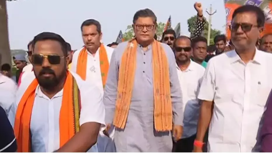Baijayant Panda in a grey kurta and orange stole walking with party workers through the constituency